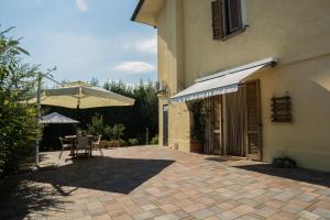 patio ze stołem i parasolem w obiekcie CasaVittorio w mieście San Giovanni in Marignano