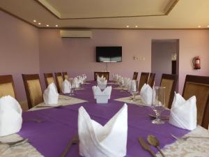 una sala de conferencias con una mesa larga con mantel púrpura en Al Ahmadi Plaza Resort, en Yanbu