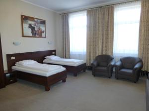 Hotel Cesarski - Kaiserhof في غيجيتسكو: غرفة فندقية بسريرين وكرسي