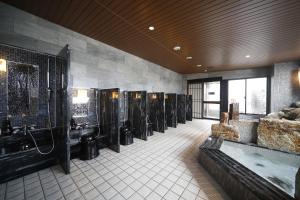 a bathroom with a bunch of sinks and a tub at Dormy Inn Miyazaki Natural Hot Spring in Miyazaki