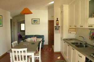 a kitchen with a sink and a table with chairs at Casa di Mary in Grottammare