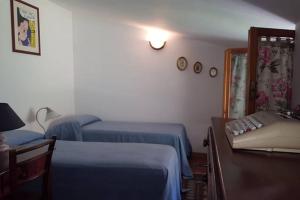 sypialnia z 2 łóżkami, stołem i kanapą w obiekcie Casa di Mary w mieście Grottammare