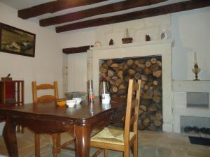 a dining room with a table and a fireplace at Le refuge du Pinail in Vouneuil-sur-Vienne