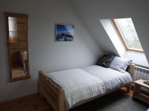 a bedroom with a bed and a window and a mirror at Domki Zawoja z Jacuzzi in Zawoja