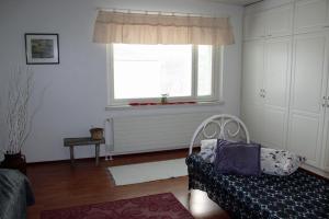 een woonkamer met een bank en een raam bij Vanhan Meijerin Majatalo Apartment in Varkaus