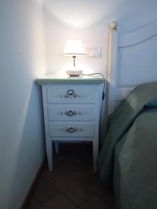a white dresser with a lamp on it next to a bed at BB Mambrotta in San Martino Buon Albergo