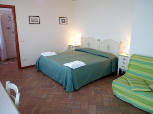 a bedroom with a green bed and a chair at BB Mambrotta in San Martino Buon Albergo