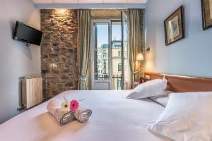 a hotel room with a bed with a stuffed animal on it at Pensión Ab Domini in San Sebastián