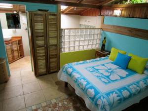 a bedroom with a bed with blue and green at Physis Caribbean Bed & Breakfast in Puerto Viejo