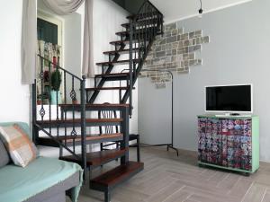 a living room with a spiral staircase and a tv at Il Nottetempo, Enna Centro in Enna