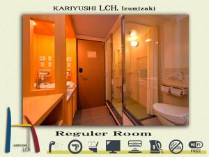 a bathroom with a toilet and a sink and a shower at Kariyushi LCH. Izumizaki Kencho Mae in Naha