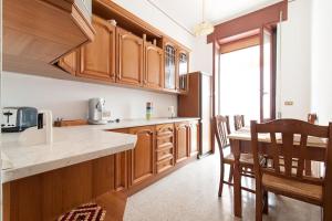 a kitchen with wooden cabinets and a table and chairs at la loggia in Brindisi