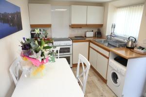 uma cozinha com uma mesa com um vaso de flores em Harbour Cottage em Stromness