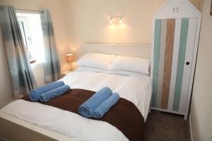 a bedroom with a bed with two towels on it at Harbour Cottage in Stromness