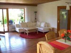 a living room with a white couch and a table at Ferienhaus Irger in Marquartstein +7 photos