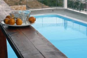 a plate of oranges on a table next to a swimming pool at Sky Beach Hotel in Agia Galini