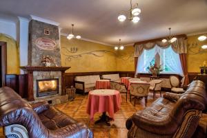 a living room with leather furniture and a fireplace at Rezydencja Piastowska in Szklarska Poręba