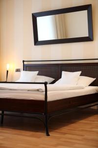 two beds in a room with a mirror on the wall at Maifeld Sport- und Tagungshotel in Werl