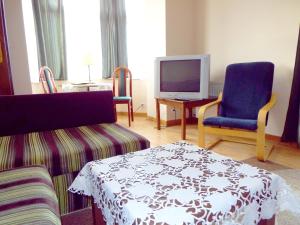 a living room with two chairs and a tv at Ośrodek Wypoczynkowy Rapsodia in Krynica Zdrój