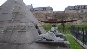 a statue of a woman laying on the side of a monument at La Maison Boulonnaise in Boulogne-sur-Mer