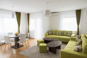サラエボにあるTuristic Apartments Centar Sarajevoのリビングルーム(緑のソファ、テーブル付)