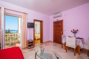 a living room with a glass table and a balcony at Apartments Silence in Mlini
