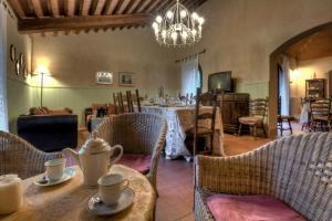 ein Esszimmer mit Tischen, Stühlen und einem Kronleuchter in der Unterkunft Agriturismo il Prato in Palaia