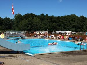 a large swimming pool with people in the water at City Camping Hjørring in Hjørring