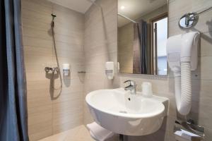 y baño blanco con lavabo y ducha. en Hôtel Thalassa, en Saint-Florent
