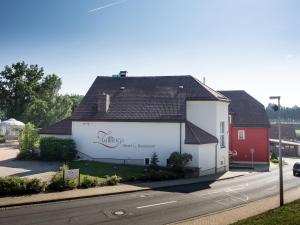 ein weißes Gebäude mit einem Schild an der Seite in der Unterkunft bei Zwillings Hotel & Restaurant in Hilbersdorf