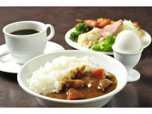 a table with a plate of rice and a cup of coffee at Hotel Global View Kushiro in Kushiro