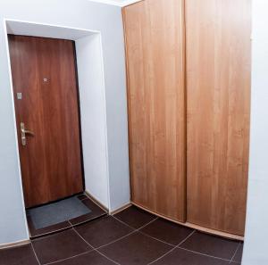 チュメニにあるApartamienty na Profsoiuznoiのタイルフロアの客室で、木製のドアが2つあります。