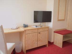 a room with a desk with a television on it at bei Zwillings Hotel & Restaurant in Hilbersdorf