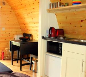 a kitchen with a counter with a microwave and a table at The Rainbow POD in Milltown Malbay
