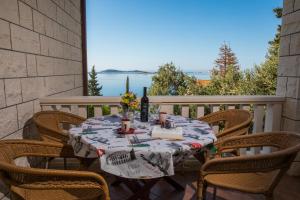 a table and chairs on a patio with a view of the water at Apartments Silence in Mlini