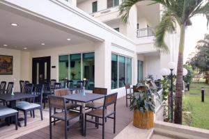 a patio with tables and chairs and a palm tree at Somerset Vientiane in Vientiane