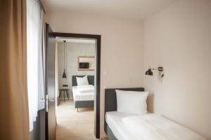 a bedroom with two beds and a mirror at Green Spirit Hotel in Regensburg