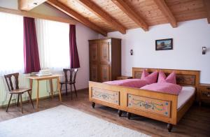 a bedroom with a bed and a table and chairs at Bauernhof Entalhof in Finkenberg
