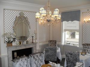 a living room with a fireplace and a chandelier at Jessop House in Tewkesbury