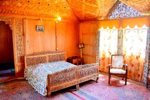 a bedroom with a bed and a chair at Kings Houseboats in Srinagar