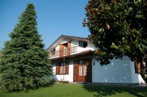 duży dom z drzewem przed nim w obiekcie Cascina36 B&B w mieście Pregnana Milanese