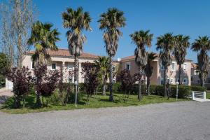 ein Gebäude mit Palmen davor in der Unterkunft Hôtel Thalassa in Saint-Florent