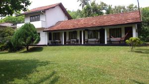 a house with a large yard in front of it at 4 Seasons Guesthouse in Hikkaduwa