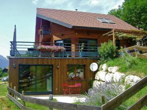 a wooden house with a balcony on top of it at Gîte Le Cerf de Belledonne in Sainte-Agnès