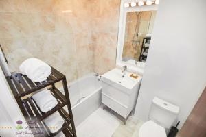 a bathroom with a sink and a toilet and a tub at Thistle Apartments-City View Apartment in Aberdeen