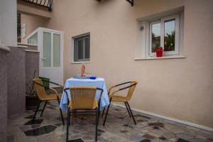 einem Tisch mit Stühlen und einem blauen Tischtuch darauf in der Unterkunft D'Angellis Livaja Apartments in Trogir