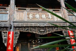 a wooden door with chinese writing on it at Pingyao Laochenggen Inn in Pingyao