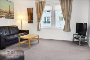 uma sala de estar com um sofá e uma televisão em Thistle Apartments-City View Apartment em Aberdeen