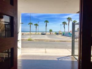 a view of a parking lot with palm trees and the ocean at Hotel Puerto Chinchorro in Arica