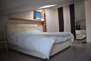 een slaapkamer met een groot wit bed in een kamer bij Bilocale Attico Villamarina in Cesenatico